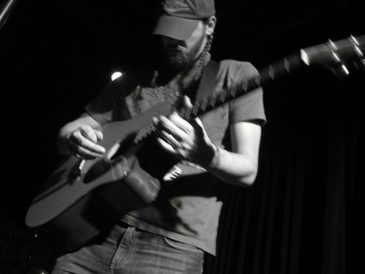 Image of Dan Grimm playing guitar. Photo by Amanda Peacock